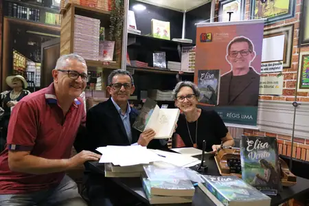 trio com o livro aberto na dedicatória